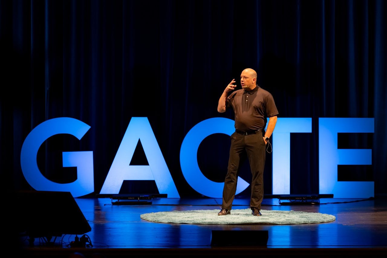 Jason Van Nus speaking on stage at the GACTE conference